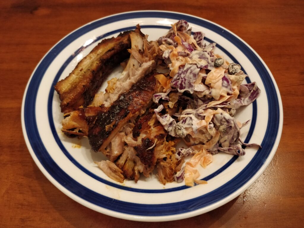 Slow-cooked BBQ pork ribs sliced into individual ribs served with red cabbage slaw.